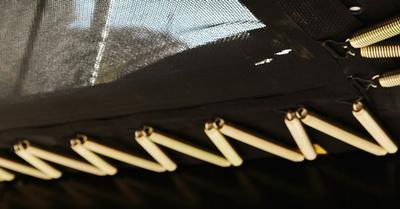 Banner con primo piano delle molle del trampolino BERG e telaio per maggiore elasticità