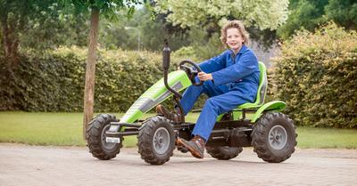 Child drives a BERG Deutz-Fahr go-kart on a paved road