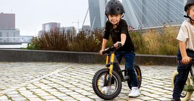 Banner con due bambini in sella a bici senza pedali BERG Biky in un ambiente urbano