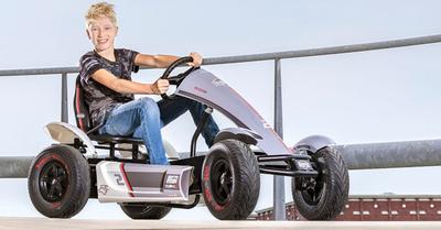 Garçon conduisant un kart à pédales BERG Race XL sur un pont en béton, bannière
