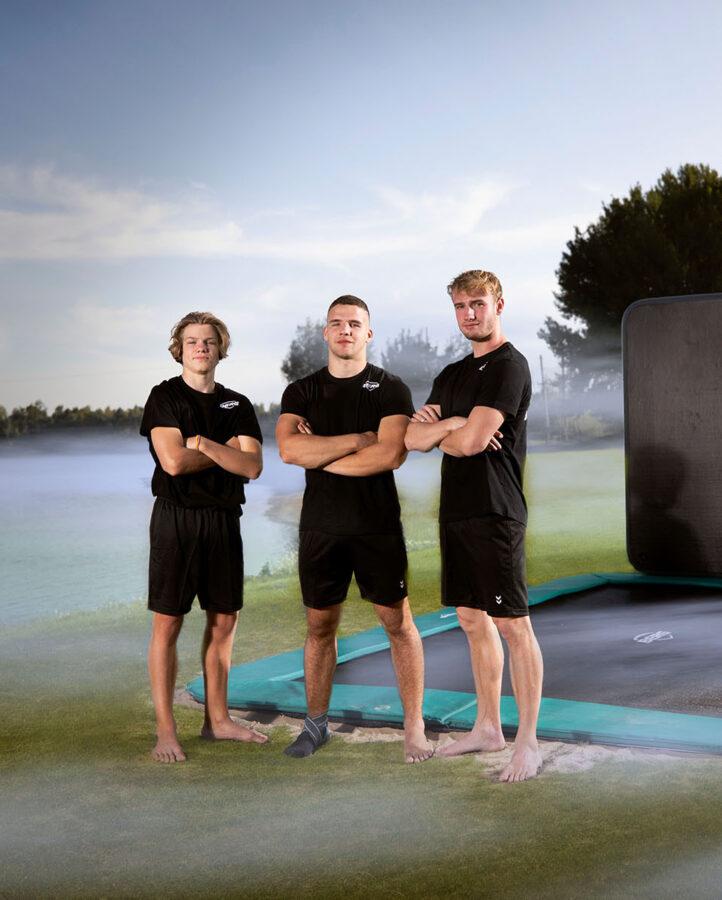 Gli atleti di BERG Masters of Bounce posano accanto a un trampolino con AeroWall