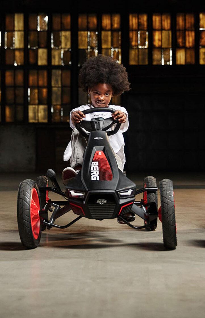 Drie kinderen racen op BERG skelters in een industriële setting