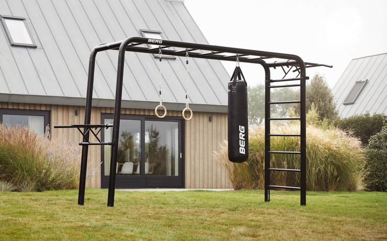 BERG PlayBase mit Boxsack, Ringen und Kletterstange als komplettes Homegym im modernen Garten