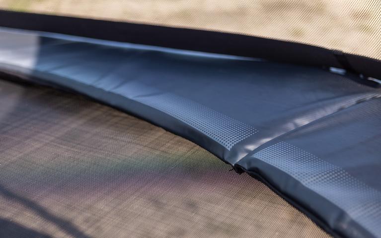 Gros plan sur le bord de protection d’un trampoline BERG en matériau solide avec finition soignée