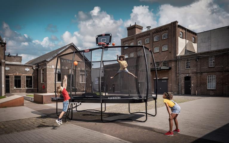 Kinder spielen Basketball auf einem BERG Trampolin mit TwinHoop in urbaner Umgebung