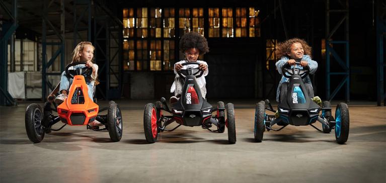 Drie kinderen racen op BERG skelters in een industriële setting