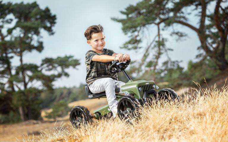Jongen rijdt op een Jeep Buzzy Sahara skelter in de natuur