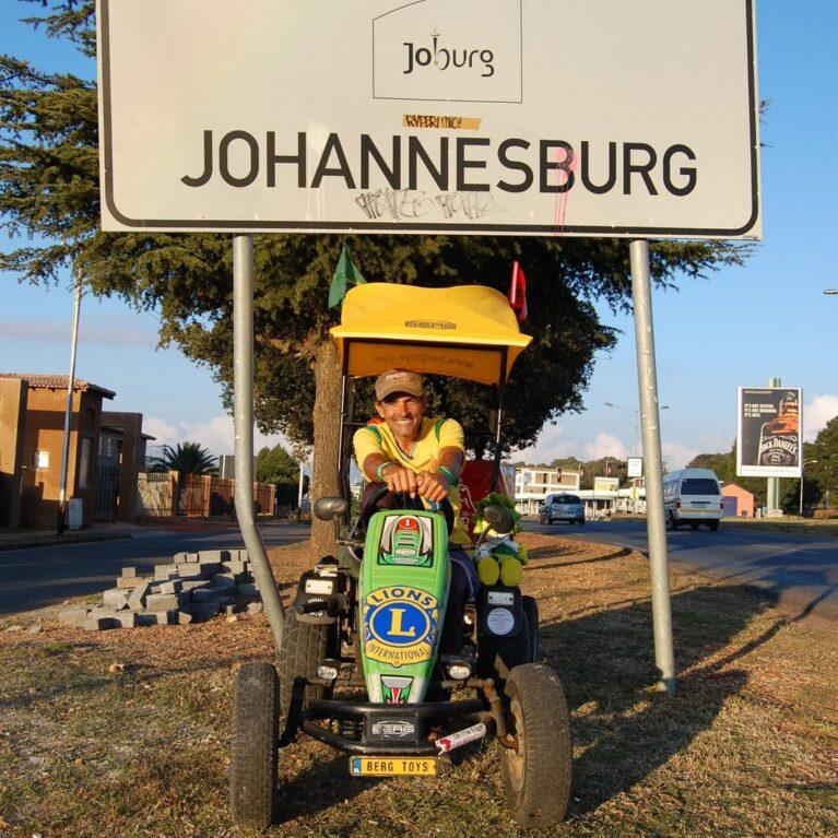 Pedal Joe arriving in Johannesburg with his BERG pedal kart at the city sign