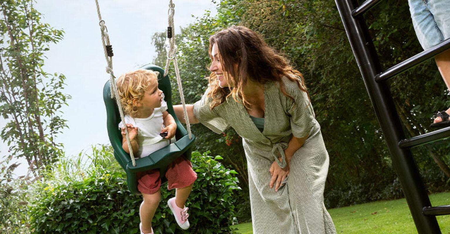 Banner of BERG PlayBase climbing frame with mother and kids at the swing in a safe garden