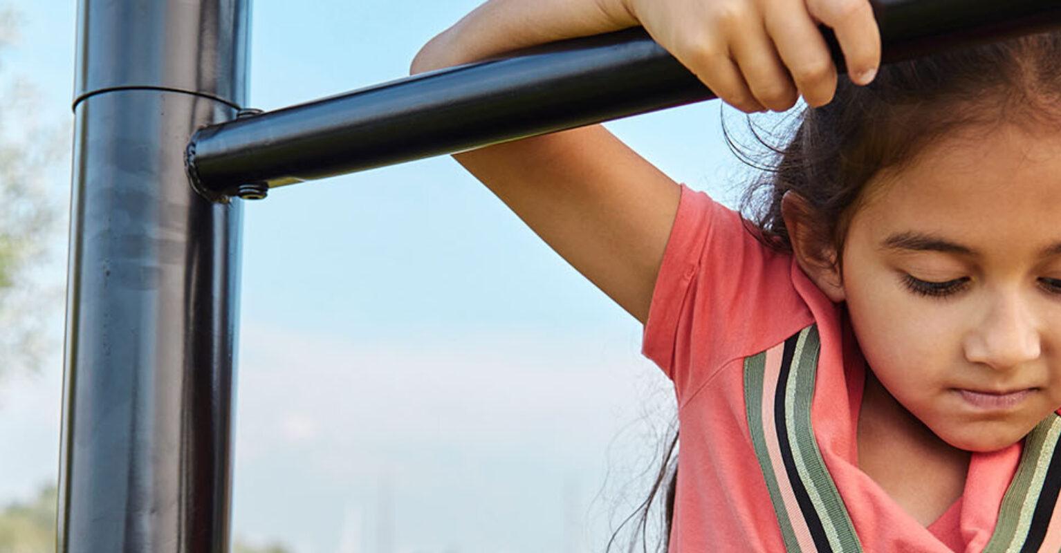 Bannerissa lapsi leikkii BERG PlayBase -putkirungolla – tukevalla ulkokiipeilytelineellä.